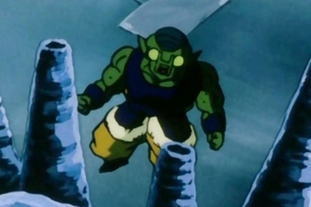 Moa de Dragon Ball Z, guerrier à la peau verte avec des yeux jaunes brillants, portant un pantalon jaune et une armure bleue, flottant dans un paysage rocheux glacé.